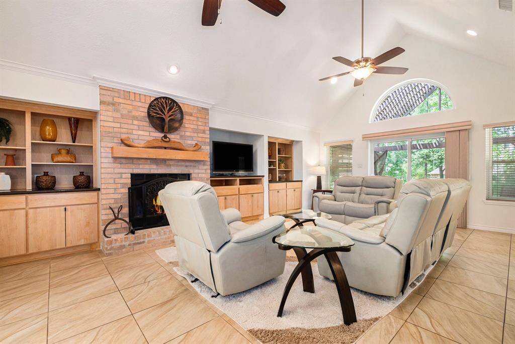 Stunning living room with custom-built-ins, a cozy fireplace, and overlooks the backyard.