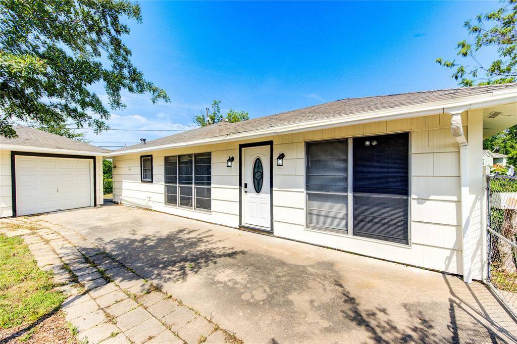 The front door is just inside of the gated driveway, and it includes a one-car garage.