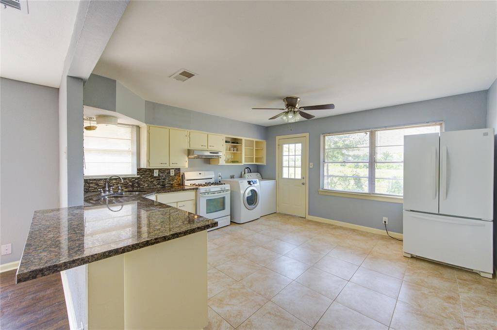 Open kitchen with breakfast bar, all appliances included. The kitchen window looks down onto the Bayou.
