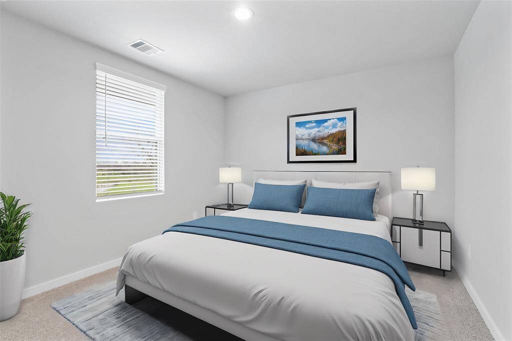 This secondary bedroom features high ceilings, recessed lighting, custom paint, plush carpet, and a large window with privacy blinds!