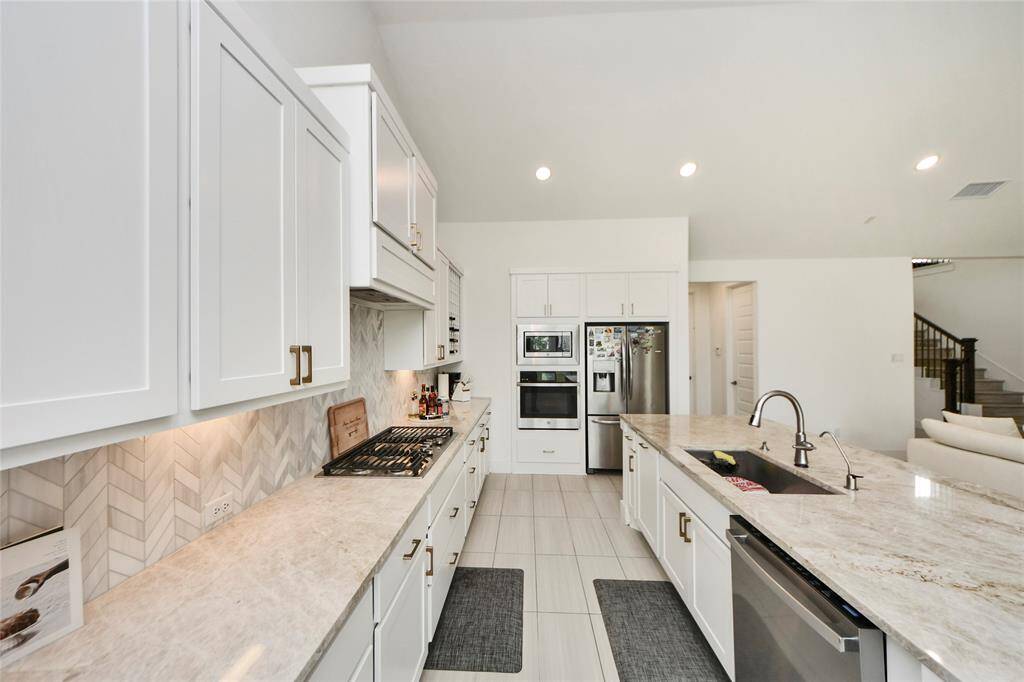 A chef’s dream with ample counter space, deep drawers, and a sleek gas cooktop set against designer tilework.