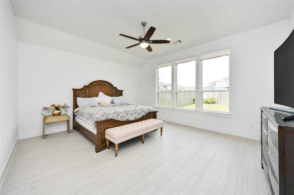 Bright and airy primary bedroom with a wall of windows overlooking the backyard and plenty of space for your favorite furnishings.