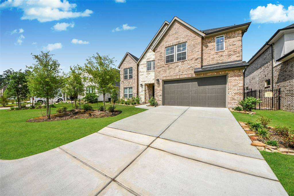 Extended driveway shot emphasizing the spacious parking area and pristine landscaping leading to the front entry.