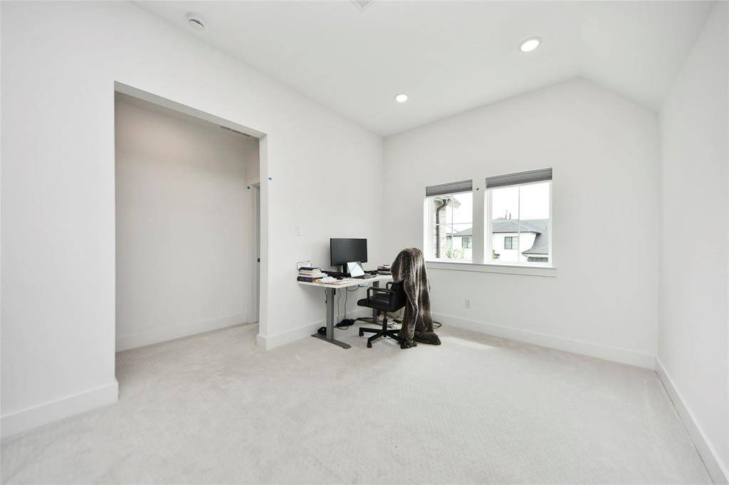 Flexible loft space with a desk area and natural light, perfect for a study or home office.