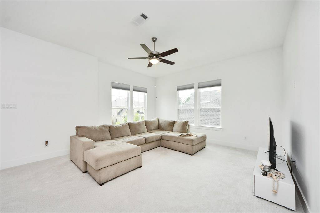 Bright and versatile upstairs retreat with plush carpeting, multiple windows for natural light, and ample space for a large sectional sofa and TV setup—perfect for lounging, entertaining, or a second family room.