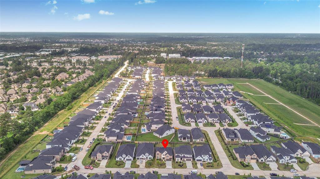 Zoomed-out drone shot placing the home within the larger neighborhood, offering a clear view of its spot within this beautifully planned community.