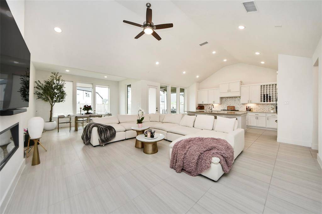 Stunning open-concept living space with soaring ceilings, sleek tile flooring, and a spacious layout ideal for entertaining.