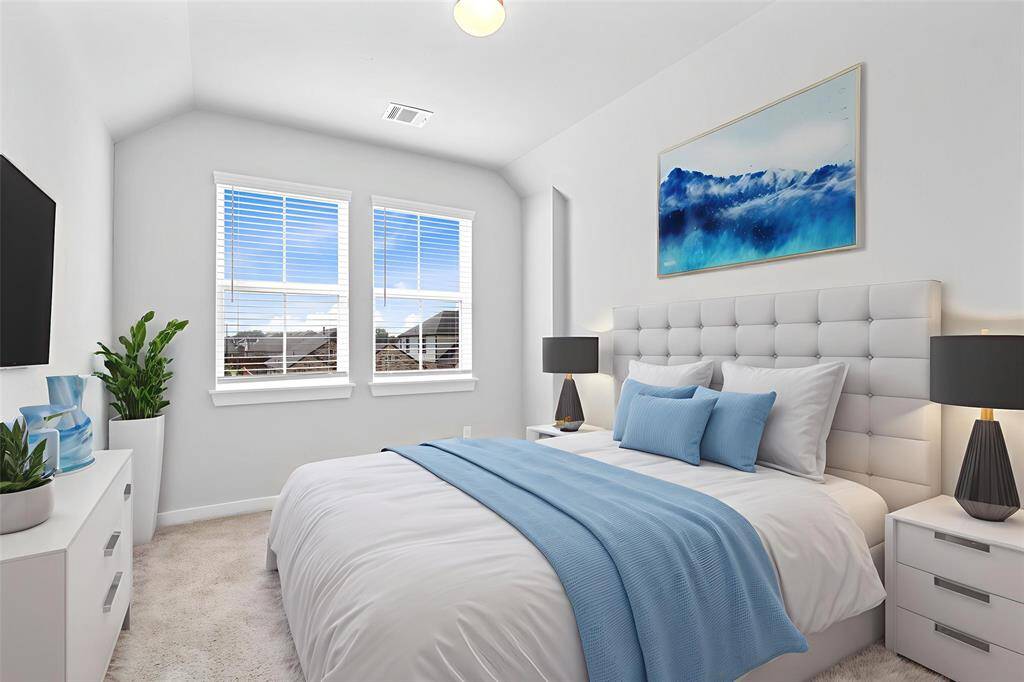Secondary bedroom features plush carpet, custom paint, high ceilings, closet space, large windows with privacy blinds, and private access to a secondary bathroom.