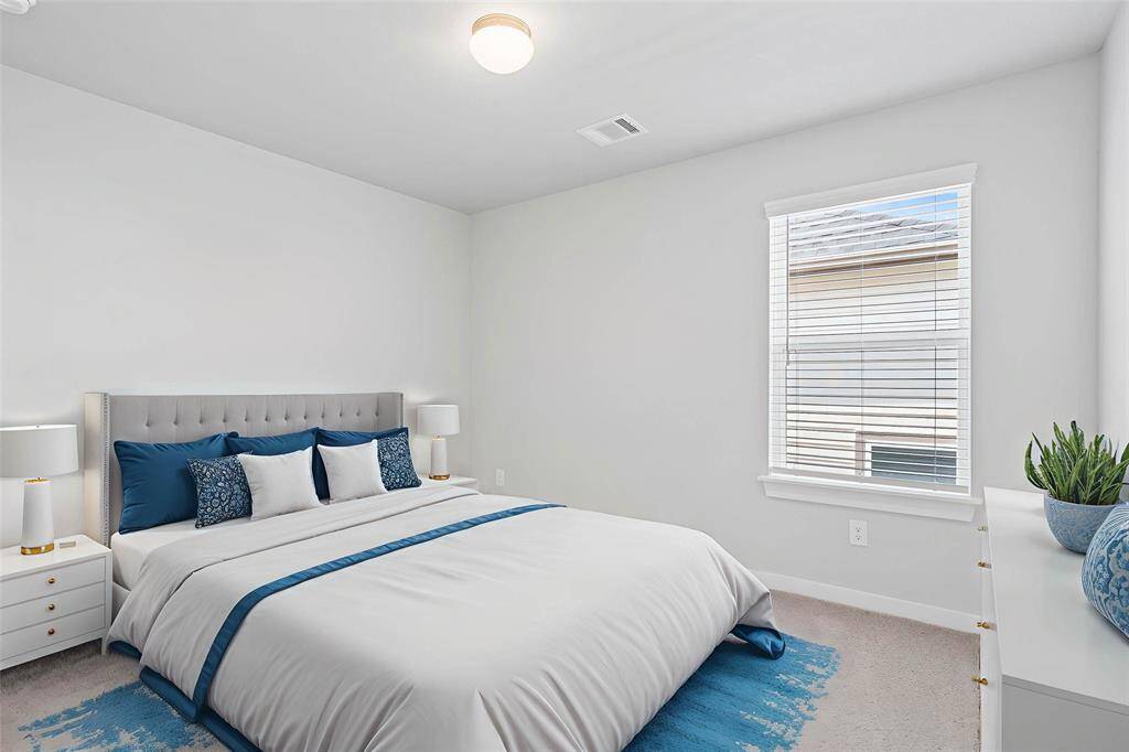 Secondary bedroom features plush carpet, custom paint, high ceilings, closet space, and a large window with privacy blinds.