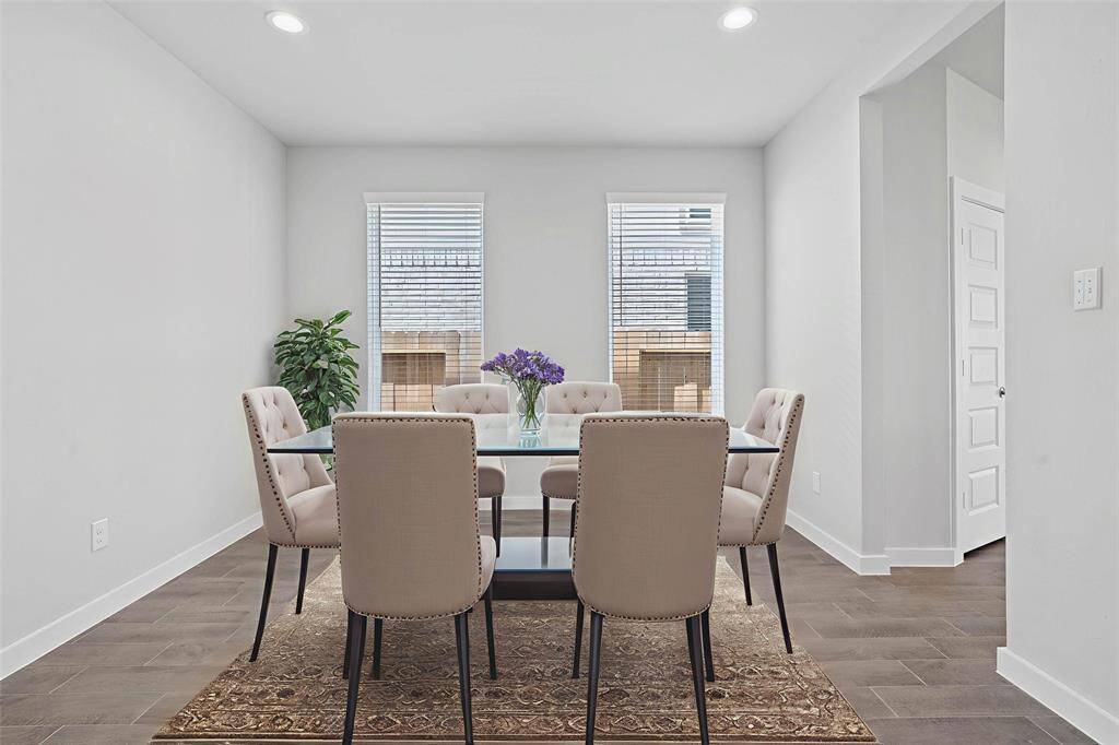 You and your guests will certainly dine in style in this amazing formal dining room! Featuring large windows with blinds, neutral paint, high ceilings, and wood look tile flooring! Perfect space to entertain family and friends!
