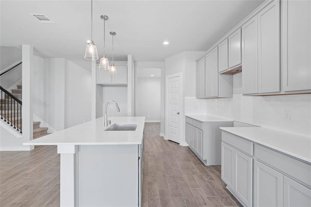 This kitchen is by far any chef’s dream! This spacious kitchen features high ceilings, stained wood cabinets, quartz countertops, SS appliances, modern tile backsplash, recessed and pendant lighting, extended counter space for breakfast bar from the kitchen island, and a walk-in pantry all overlooking your huge family room.