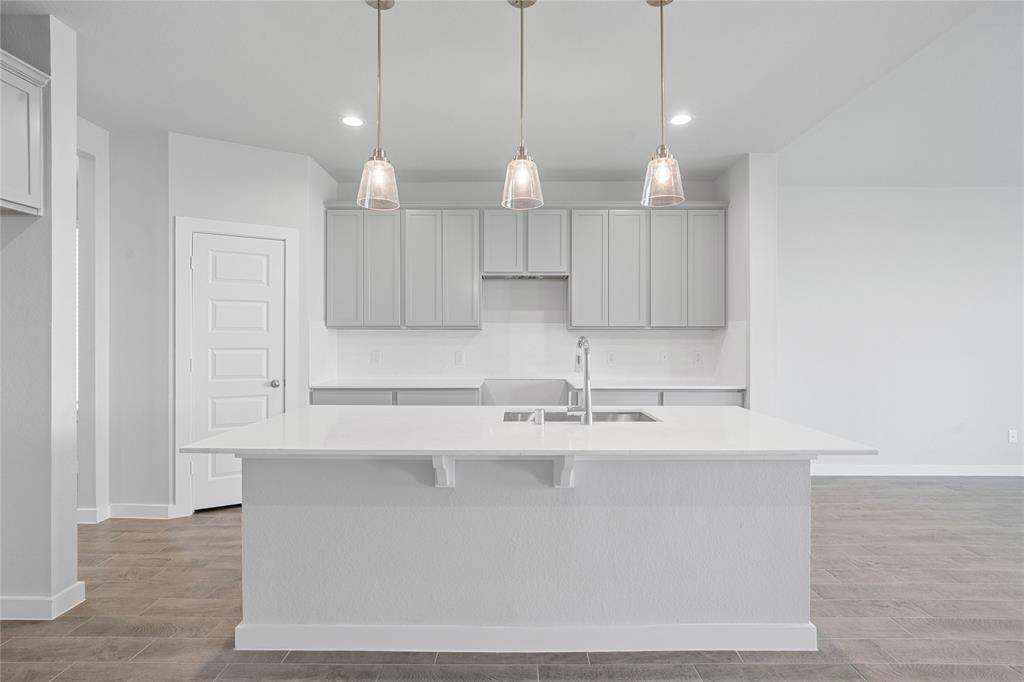 Additional view of this beautiful kitchen showcasing the large kitchen island with pendant lighting!