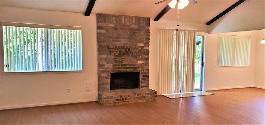 Spacious family room with beams and a gorgeous wood burning fireplace.