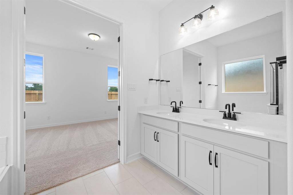The en-suite bathroom offers a spa-like atmosphere with its elegant design, high end finishes, and tasteful lighting, creating a retreat within your own home.