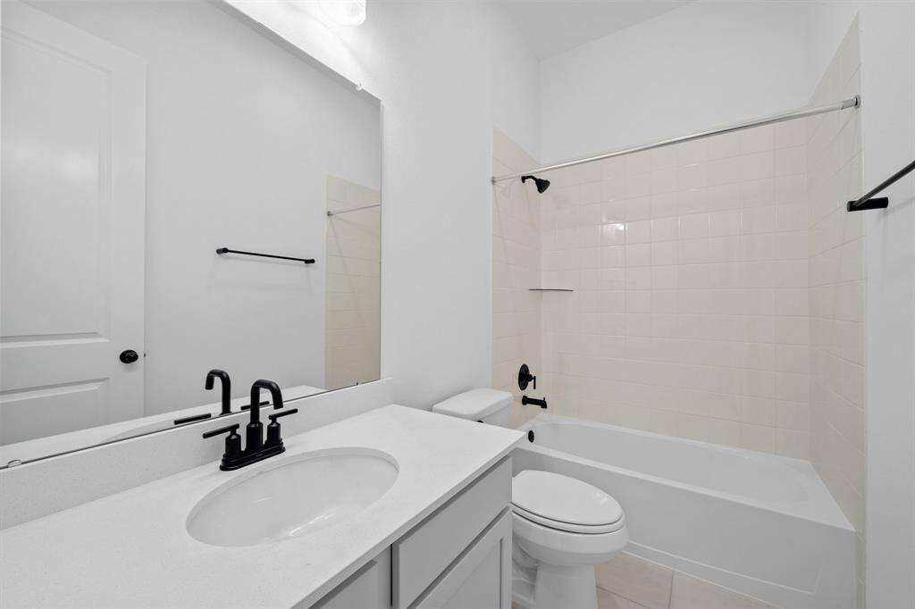 The secondary bath features tile flooring, white cabinetry and light countertops and a shower/tub combo. Perfect for accommodating any visiting family and friends.
