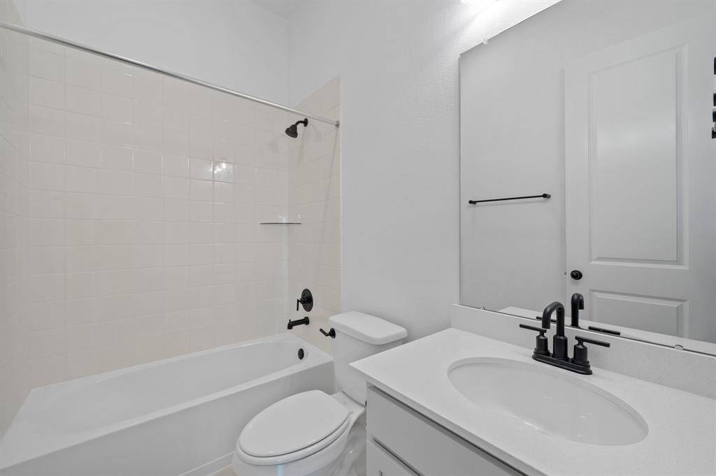 The secondary bath features tile flooring, white cabinetry and light countertops and a shower/tub combo. Perfect for accommodating any visiting family and friends.