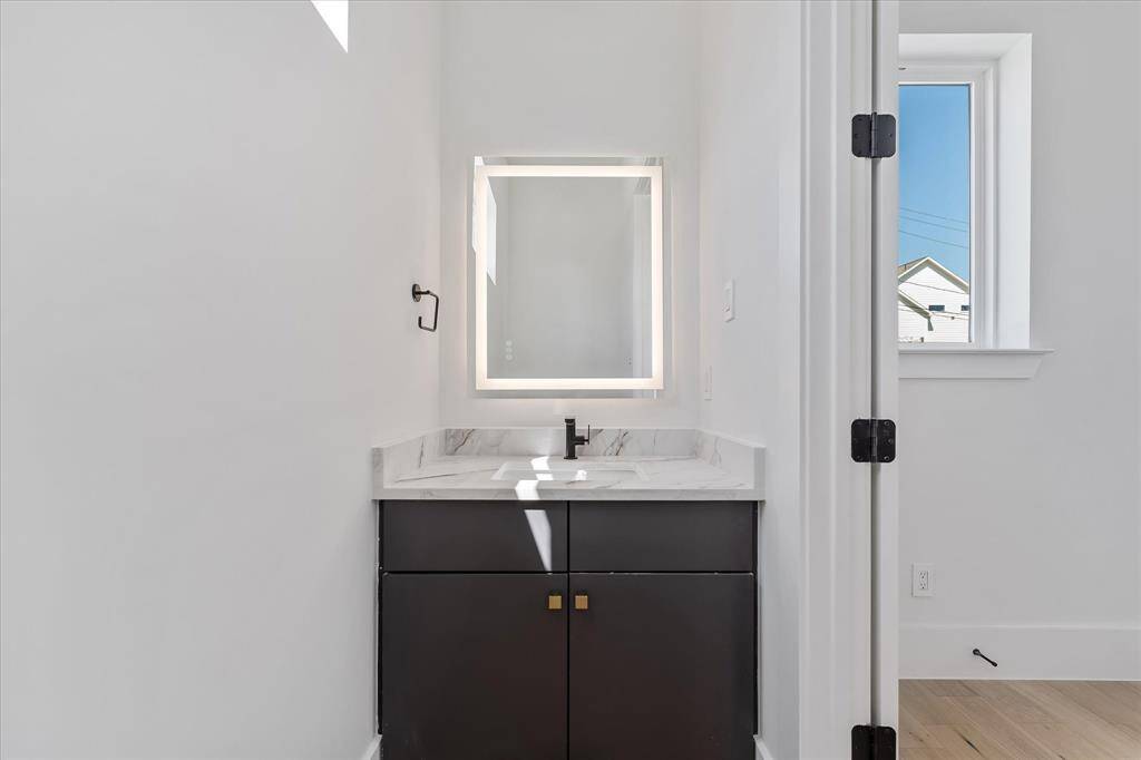 Half Bathroom: Custom built vanity with LED lit mirror and a window for natural light.