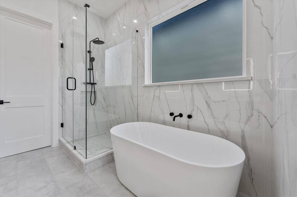Primary Bathroom: Soak Tub, oversided shower and floor to ceiling tile.