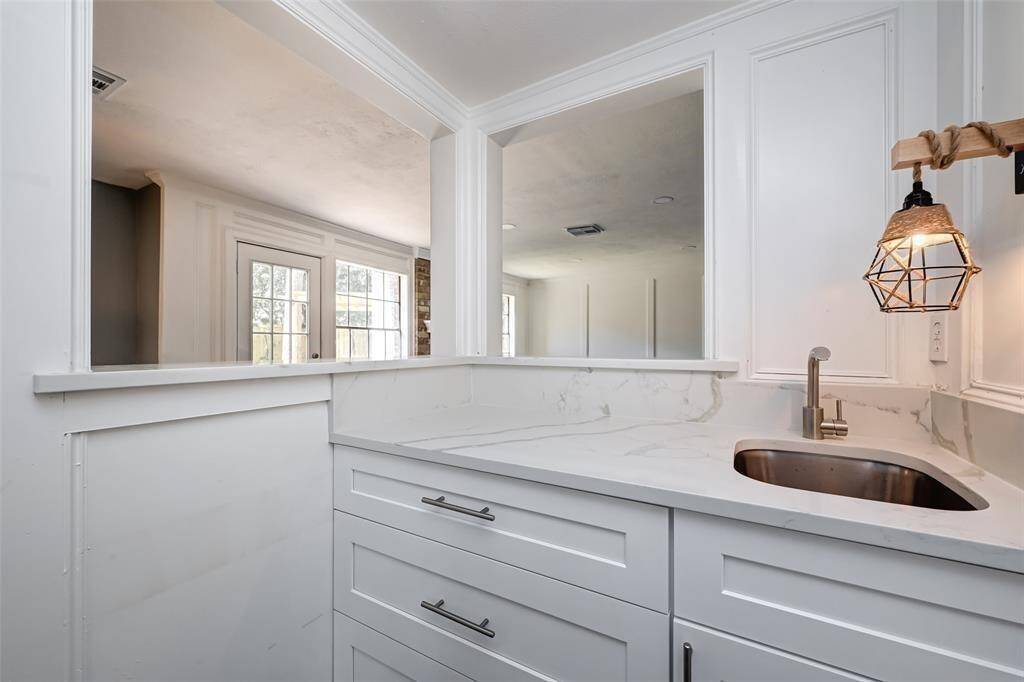 The wet bar right off the living room features plenty of storage space.