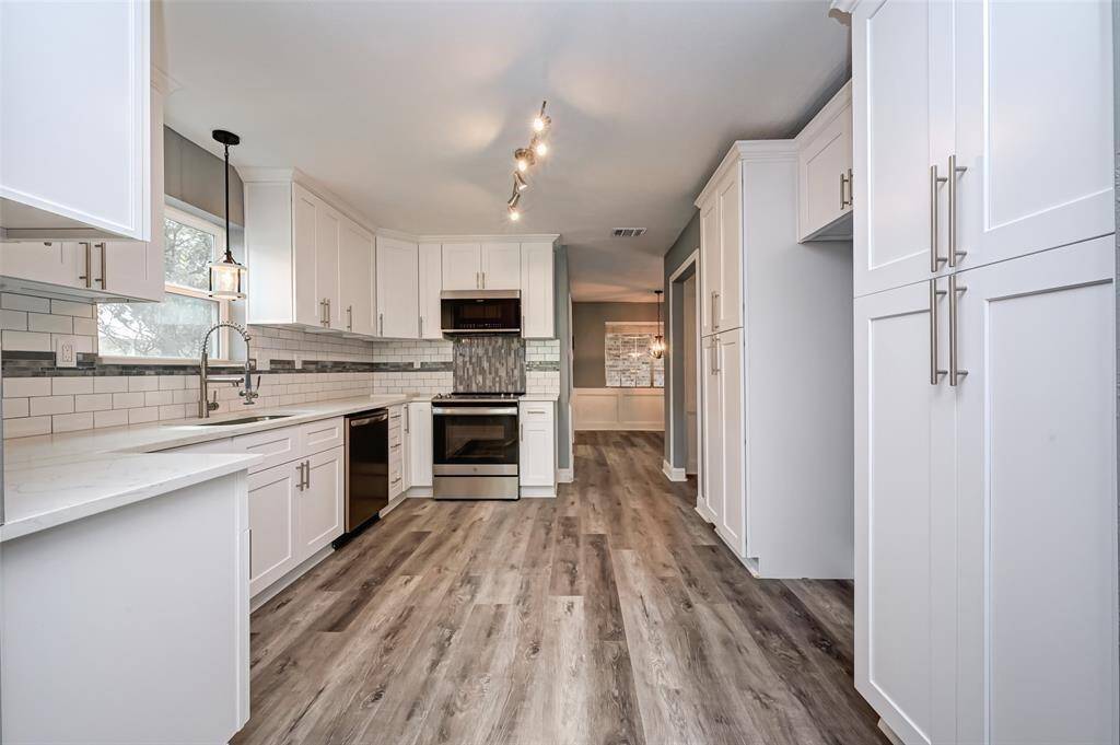 The kitchen features white cabinets,creating a clean and timelessaesthetic.