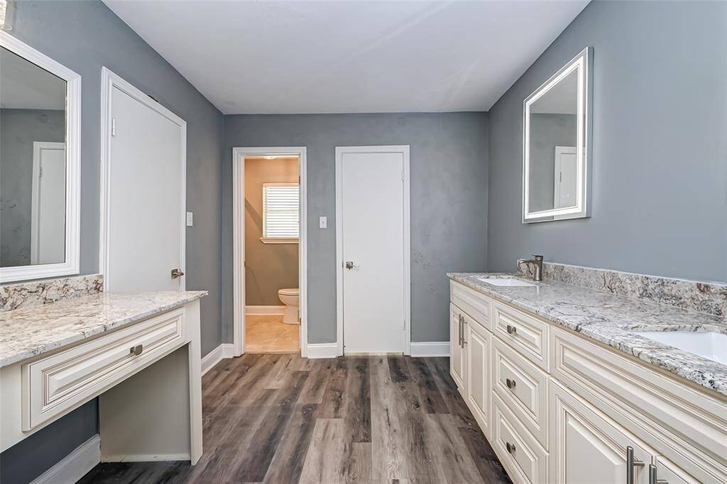 The primary bathroom features dual sinks and a vanity area.