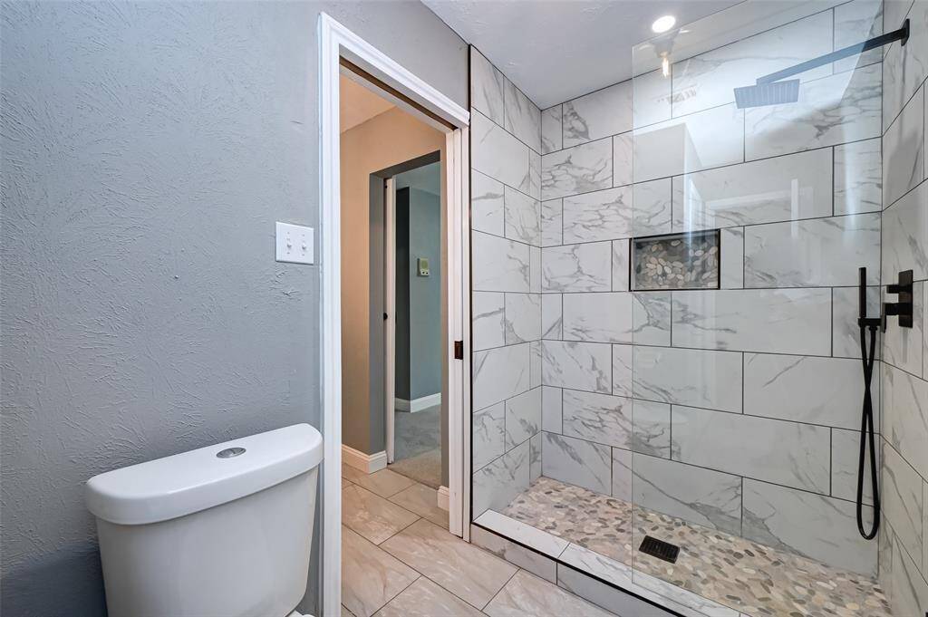 The primary walk-in shower features tile surround.