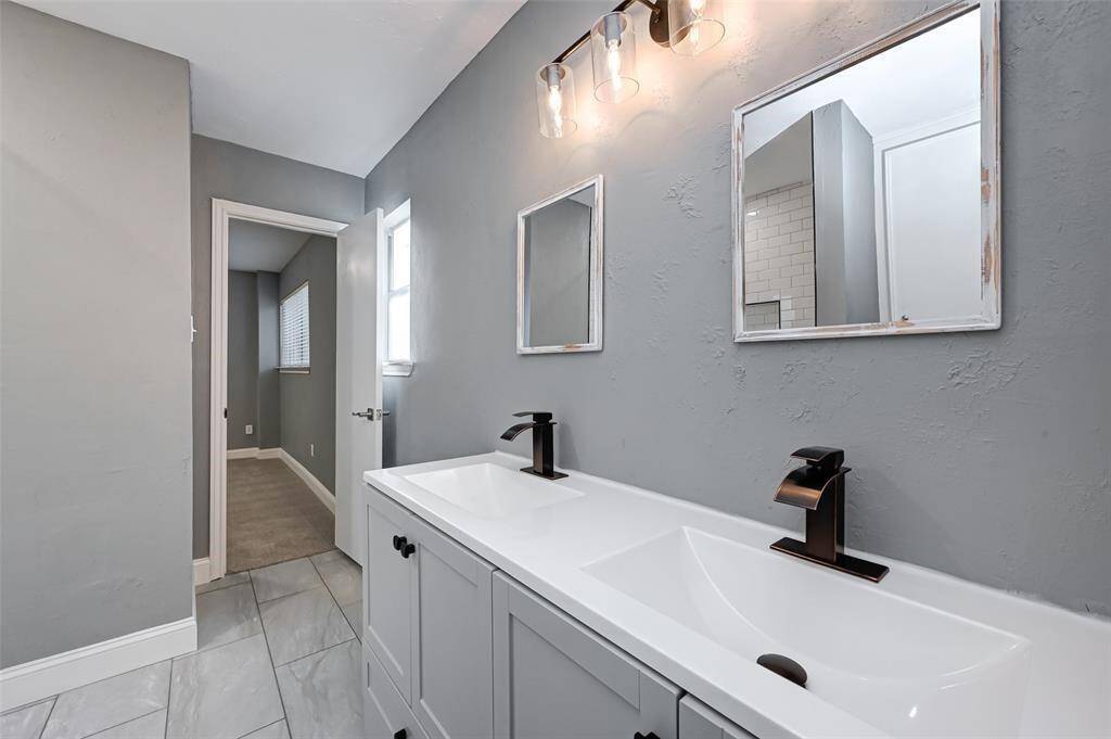 Secondary bathroom features dual sinks, tile floors, and custom paint.