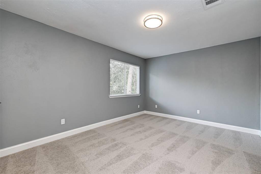 Third bedroom features awindow and plush carpet.