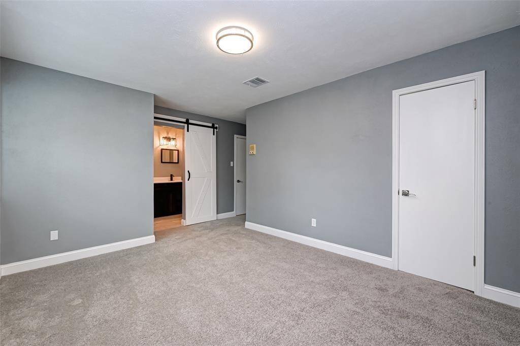 Fourth bedroom features awindow and plush carpet.