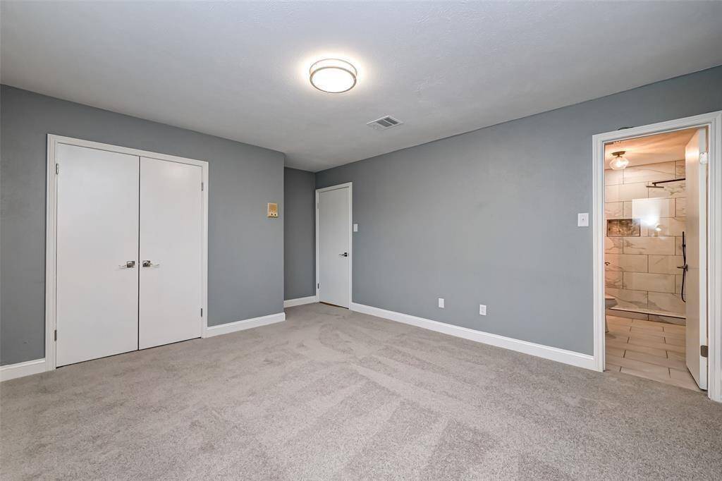 Fifth bedroom features awindow and plush carpet.