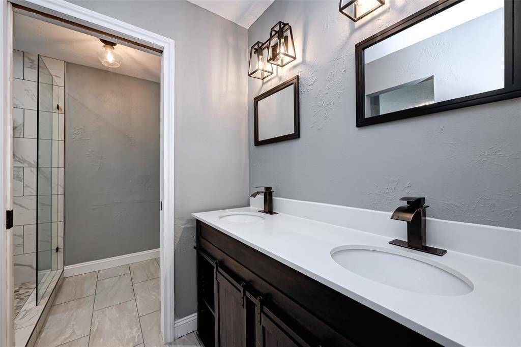 Third bathroom features dual sinks, tile floors, walk-in shower, and custom paint.