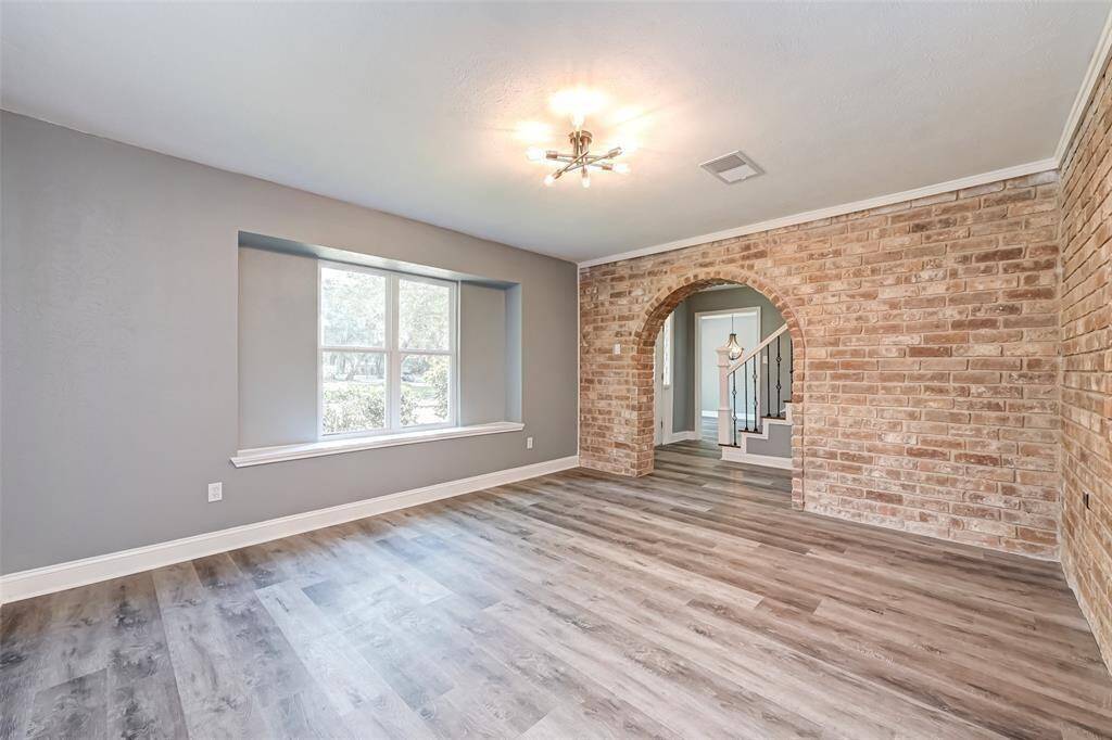 The den features brick accent walls and large windows.
