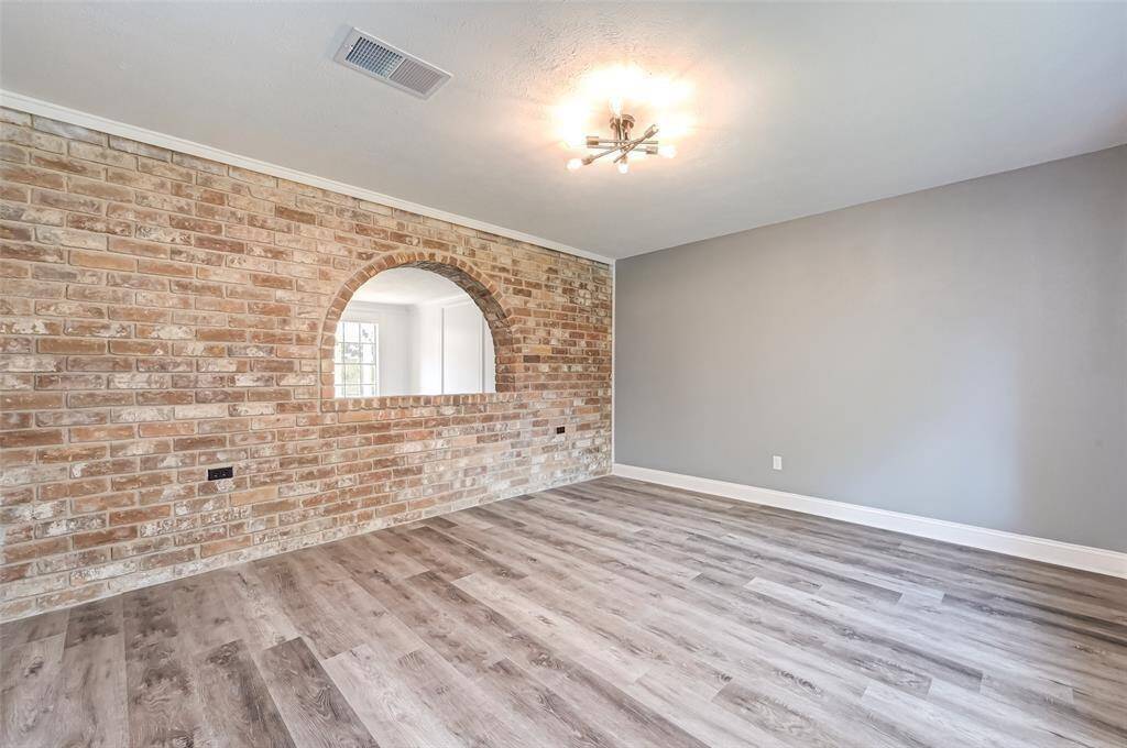 The den features brick accent walls and large windows.