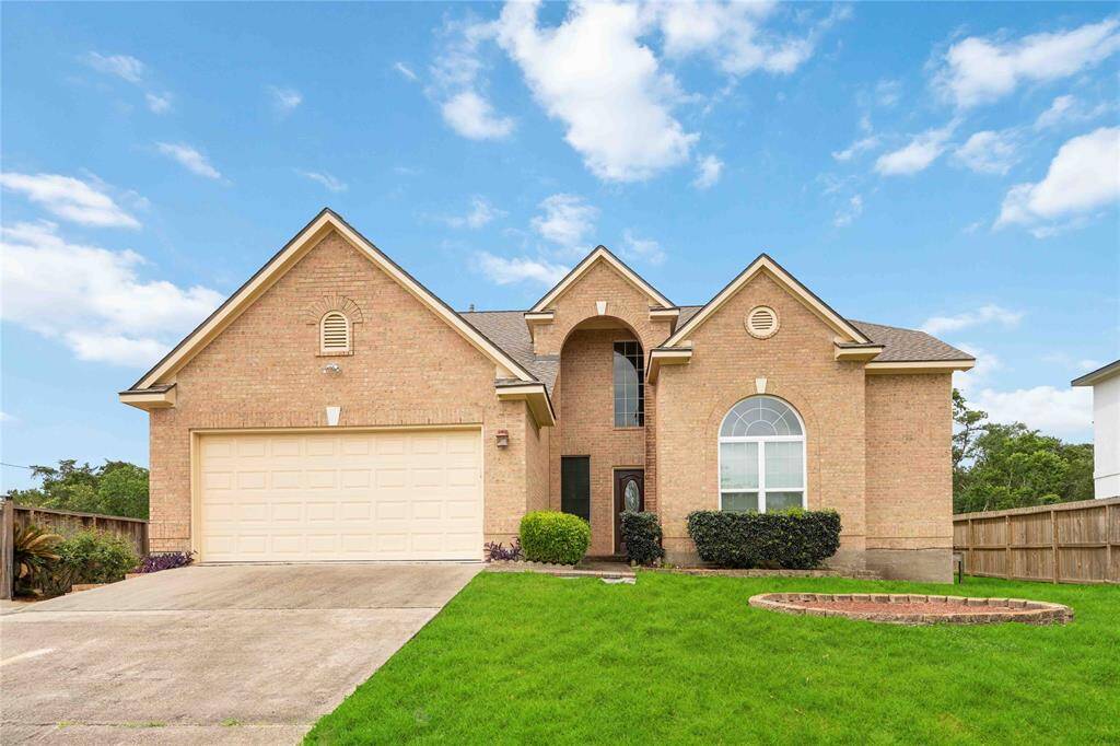 This is a spacious two-story brick home with a well-maintained front yard. The house boasts a two-car garage, large arched windows, and a welcoming entrance. Perfect for families seeking curb appeal and a comfortable living space.