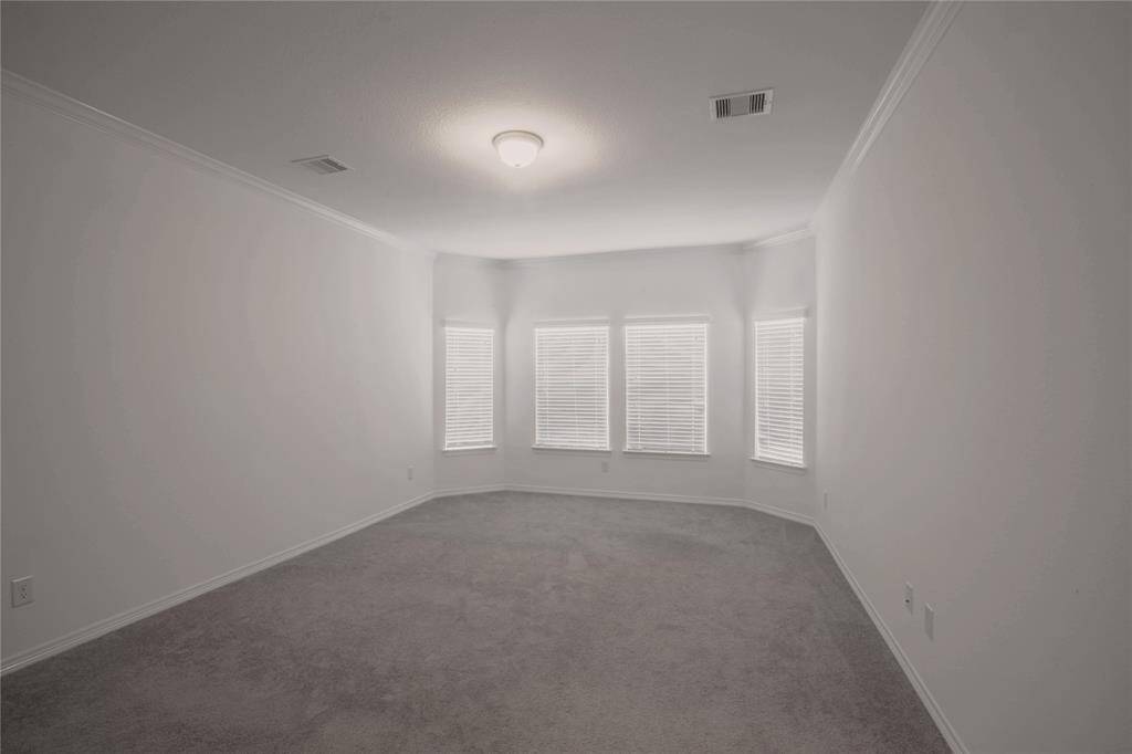 Spacious primary bedroom with bay window.