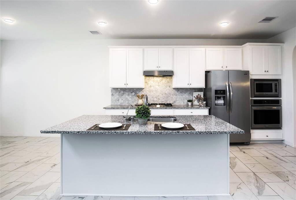 Gourmet Island Kitchen with Granite counter top, gas cook top, water filter system, water softener system,and tile floor. Refrigerator is included.