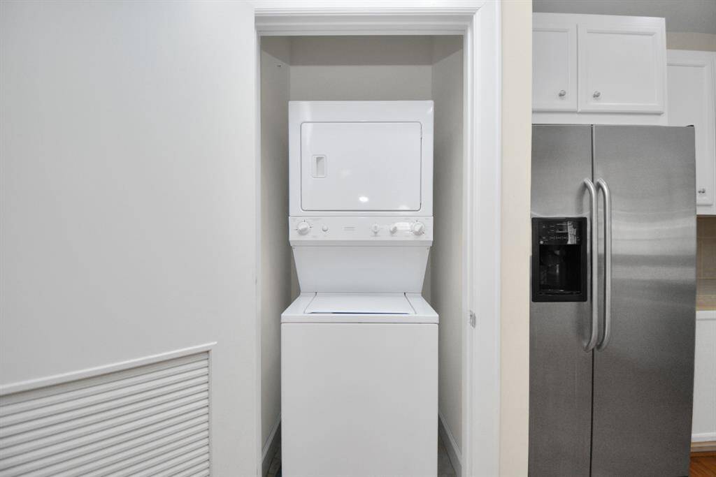 new stacked washer and dryer in the kitchen area comes with the rental unit.