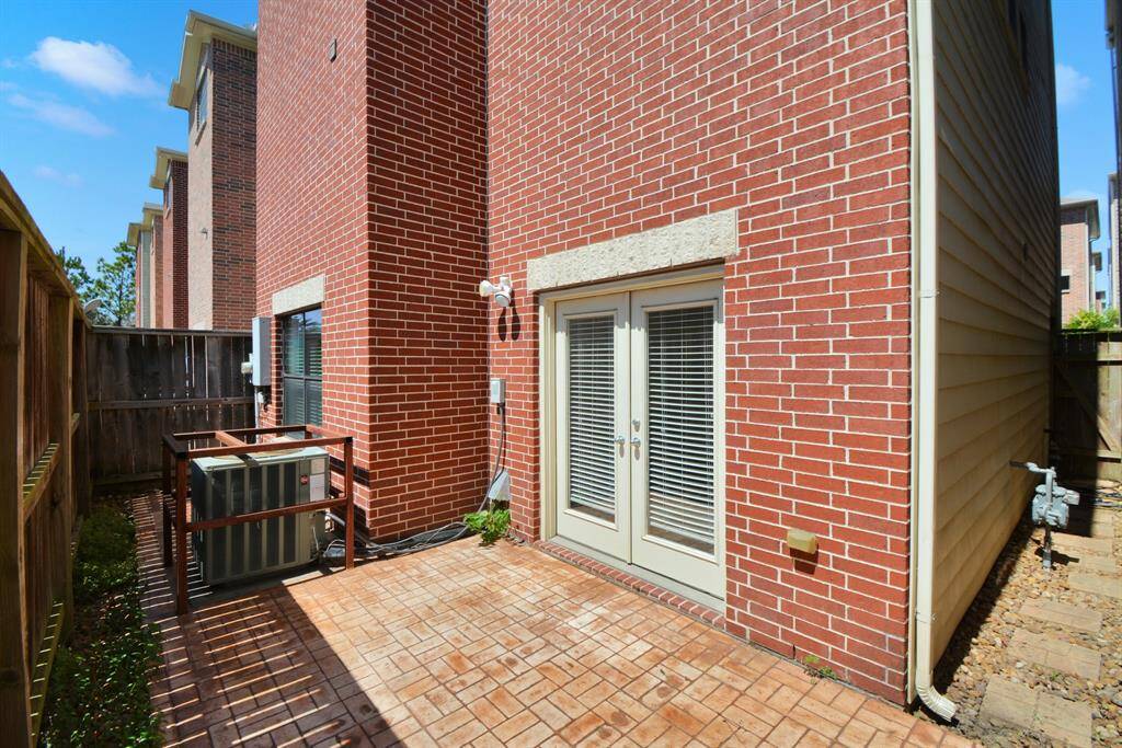 The private fenced in patio with pavers for low maintenance outdoor living.  The doors lead into one of the bedrooms.
