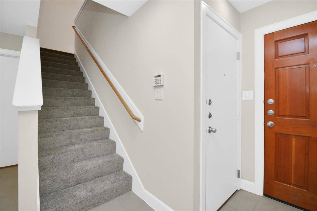 As you enter the home, the garage entrance is to the right, followed by the new grey carpeted stairs to the main living space on the second floor.