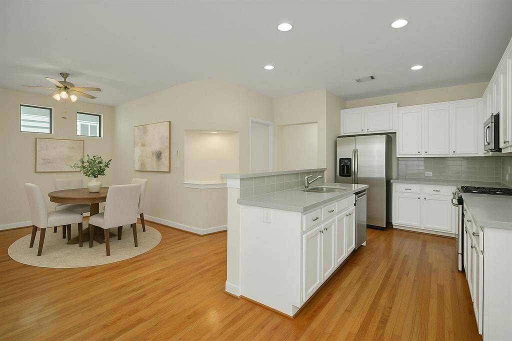 Virtually Staged dining room - Bright kitchen with island that has space for barstools that flows into the dining space.