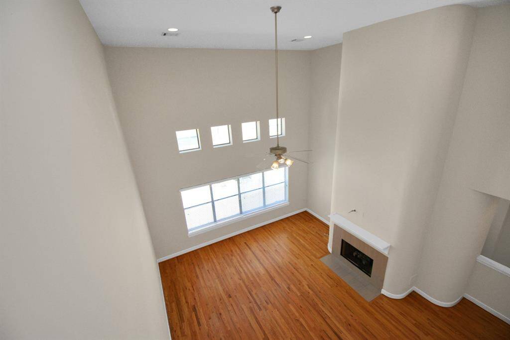 A view of the living room from the primary suite landing on the 3rd floor showcases the soaring ceilings in the living space.