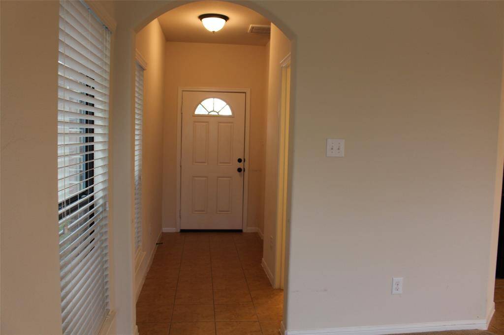 Tile floor in entryway and neutral wall color throughout the house.