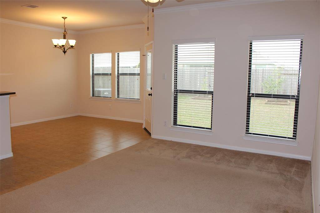 Spacious family room with lots of natural lighting and a ceiling fan.