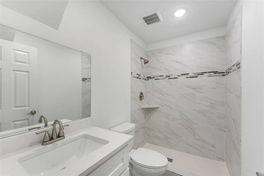 There are stunning finishes at every angle! This first floor bathroom has quartz counters, and calming gray tile with design inlay.