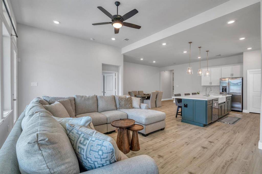 This open-concept living area with light wood flooring and neutral tones enhance the bright, airy feel, perfect for entertaining.