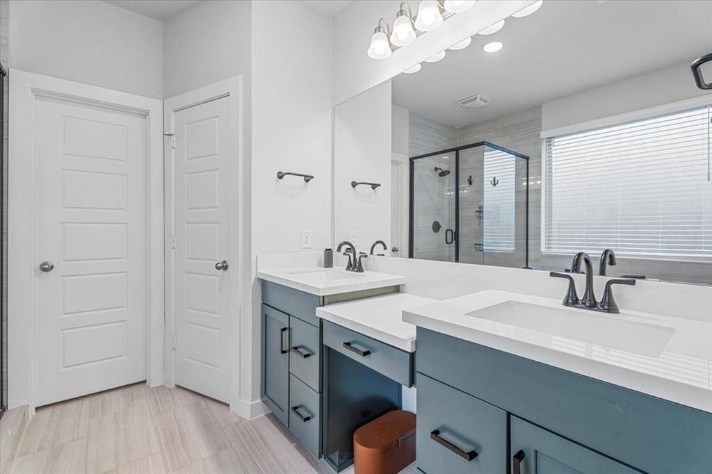 The primary bath is equipped with double sinks, a sit-in vanity area, lots of light, a soaking tub and walk-in shower.