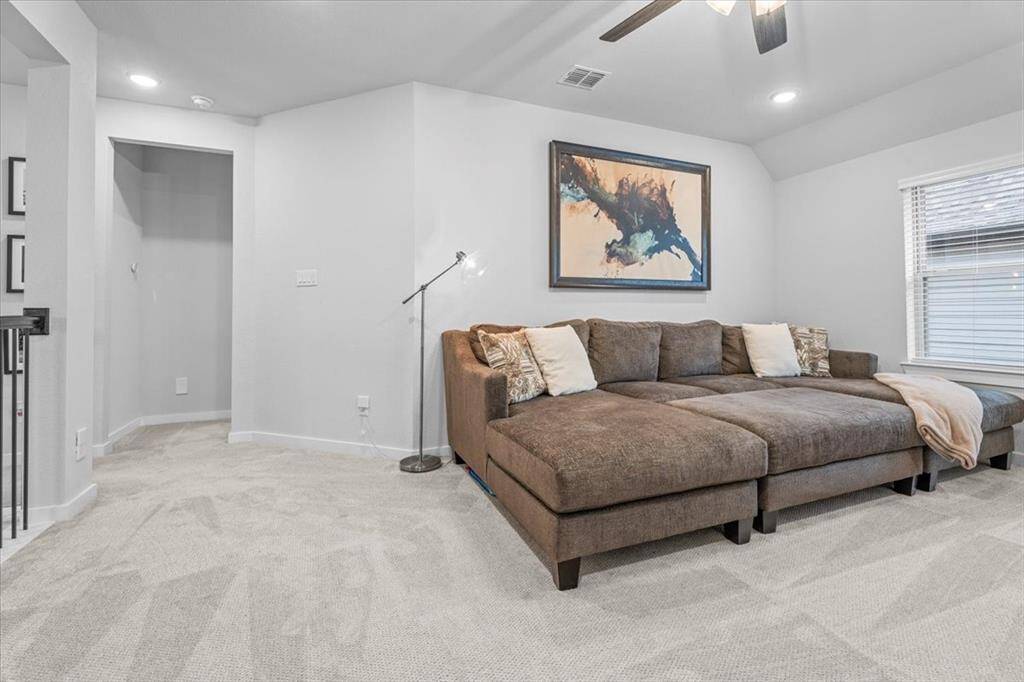 This living area is to the right as you enter the upstairs. It features ample space and modern lighting. The room is accented with a window that brings in natural light, creating a welcoming atmosphere and have a closet for extra storage or overflow from other rooms.