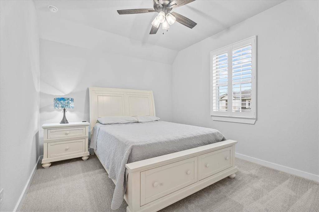 This is two of three bedrooms upstairs near the front of the house. All rooms have full or queen size beds and additional furniture. This room has an oversized window with custom shutters creating an inviting and serene atmosphere. This room has a large walk-in closet with a window as well.