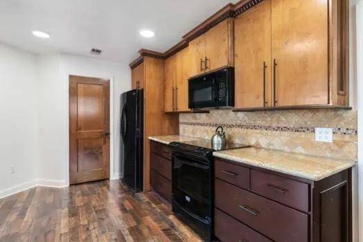 The timeless elegance of granite countertops, a tile backsplash and black appliances works fantastically together!