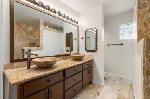 A large vanity with dual vessel sinks, a big mirror and cabinets and drawers make morning rush hour a breeze!